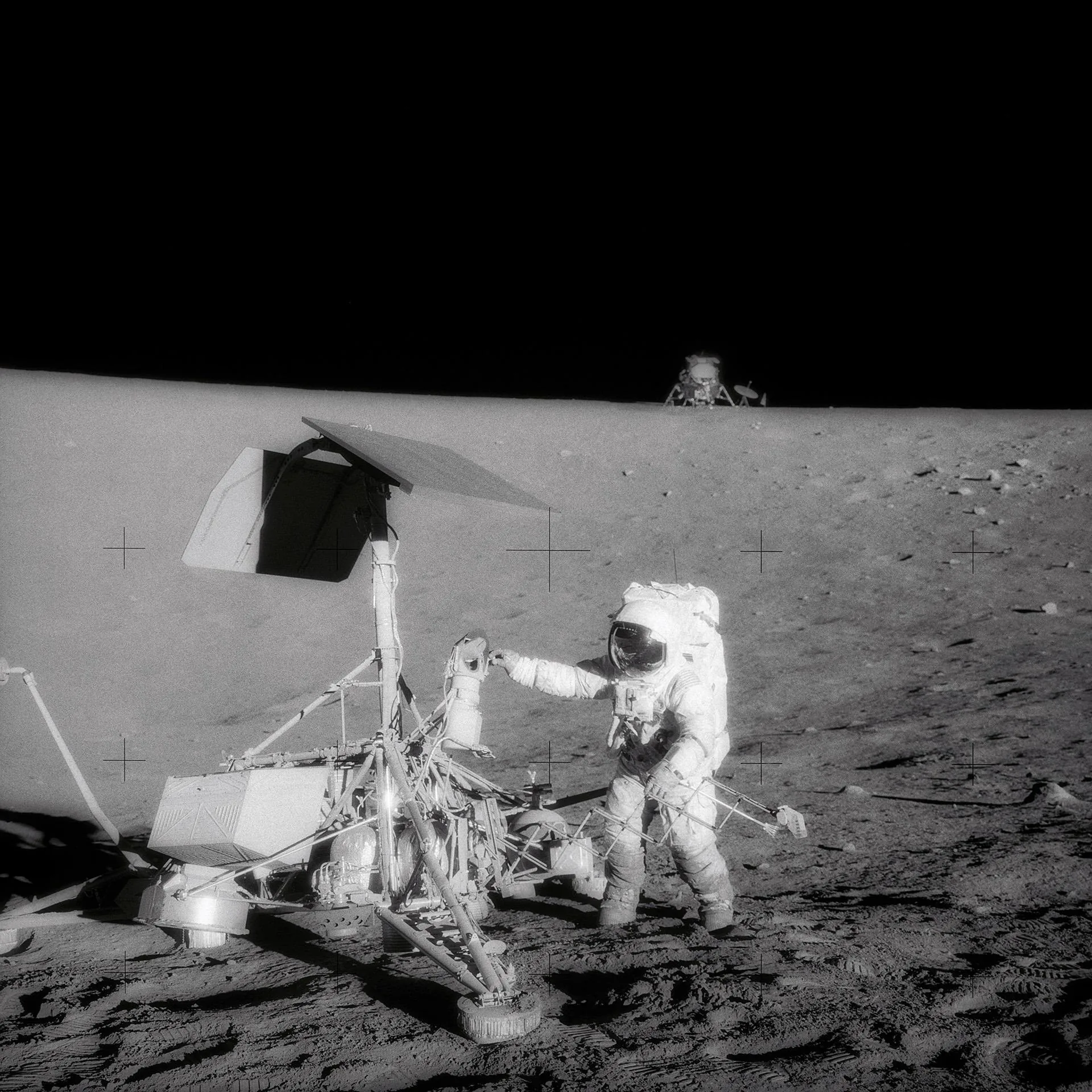 Astronauta Pete Conrad examinando la sonda Surveyor 3 en la Luna durante Apolo 12, con el módulo lunar Intrepid visible al fondo.