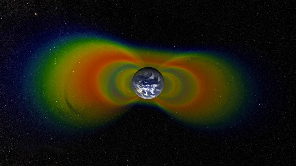 Visualización científica de los cinturones de Van Allen, con regiones de partículas energéticas representadas en distintos colores alrededor de la Tierra.