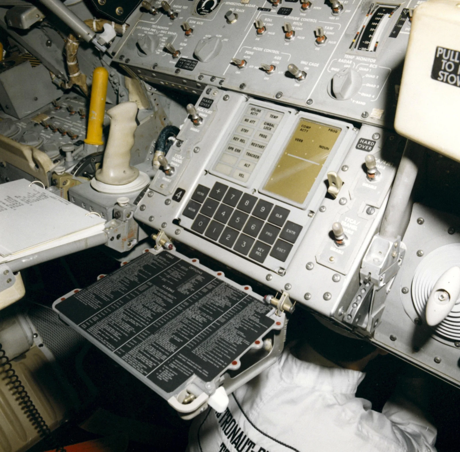 Panel de control del módulo lunar Apolo con la interfaz DSKY, que incluye una pantalla numérica y un teclado para interactuar con la computadora de guiado.