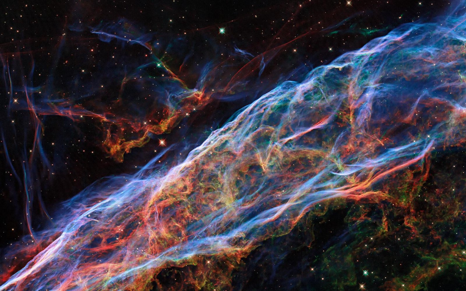 Filamentos azulados y rojizos de la nebulosa del Velo, restos de una supernova observados por el telescopio espacial Hubble.